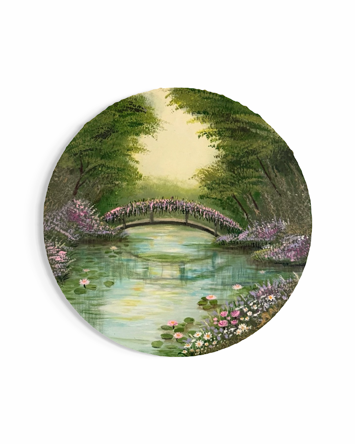Stone bridge over a lily pond in a lush garden